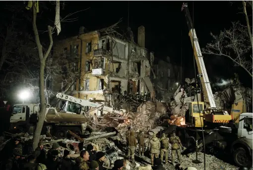  ?? ?? Rescuers remove debris to search for survivors at a destroyed apartment building hit by a rocket during the night in downtown Kramatorsk. At least three people were killed and 20 wounded when a Russian rocket struck a residentia­l building in the centre of the eastern city. — afp