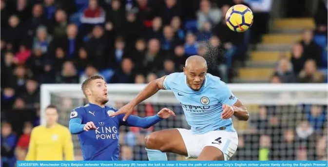  ??  ?? LEICESTER: Manchester City’s Belgian defender Vincent Kompany (R) heads the ball to clear it from the path of Leicester City’s English striker Jamie Vardy during the English Premier League football match between Leicester City and Manchester City. — AFP