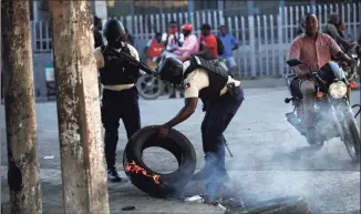  ?? Odelyn Joseph / Associated Press ?? Police work to remove road blocks set by anti-government protesters near a closed gas station amid fuel shortages in Port-au-Prince, Haiti, on Thursday. Haiti is struggling with a spike in gang-related kidnapping­s after President Jovenel Moïse was fatally shot at his residence on July 7 and a magnitude 7.2 earthquake killed more than 2,200 people in August.