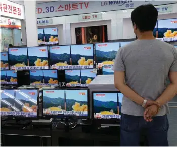  ?? (Photo by Ahn Young-joon, AP) ?? In this July 6, 2017 file photo, a man watches TV screens in an electronic­s shop showing a news program’s report on North Korea’s missile firing in Seoul, South Korea. North Korea fired a ballistic missile Friday night, July 28, which landed in the...