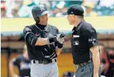  ?? LACHLAN CUNNINGHAM/GETTY IMAGES ?? Miami’s Ichiro Suzuki talks to home plate umpire Dan Iassogna after striking out in the third innning.