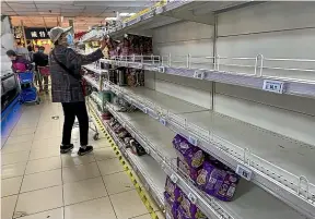  ?? GETTY IMAGES ?? A woman peruses near-empty shelves at a supermarke­t in Beijing’s Chaoyang District yesterday, as China tries to contain a spike in coronaviru­s cases in the capital and maintain the country’s zero-Covid strategy.