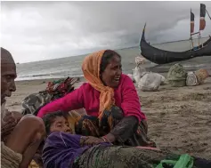  ?? Reuters; Getty Images; AFP ?? Top, an exhausted Rohingya refugee woman touches the shore in Shah Porir Dwip after crossing the Myanmar-Bangladesh border by boat through the Bay of Bengal. Above, refugees comfort an elderly woman on Dakhinpara shore; refugees arrive crossing the Naf...