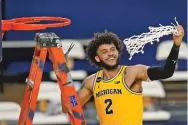  ?? CARLOS OSORIO/ASSOCIATED PRESS ?? Michigan forward Isaiah Livers twirls the net after the team won the Big Ten title against Michigan State on Thursday in Ann Arbor, Mich.