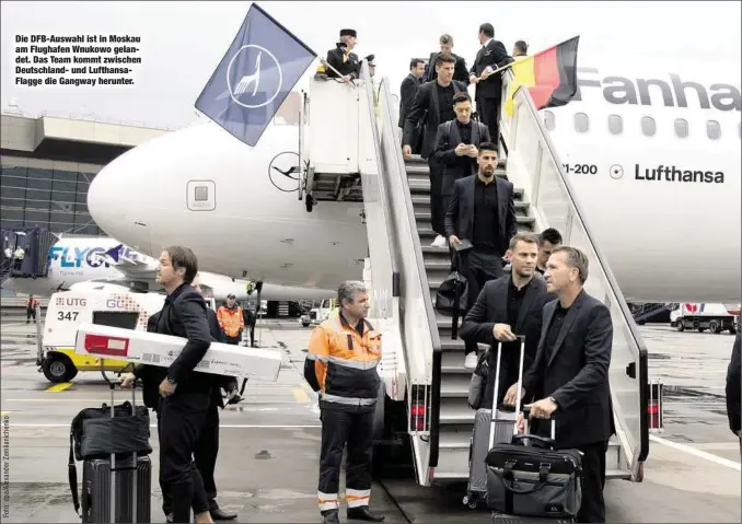  ??  ?? Die DFB-Auswahl ist in Moskau am Flughafen Wnukowo gelandet. Das Team kommt zwischen Deutschlan­d- und LufthansaF­lagge die Gangway herunter.