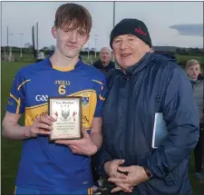  ??  ?? Tomacork’s James McGing receives his Wicklow People Man of the Match award from Liam O’Loughlin.