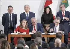  ?? AP photo ?? Seated from left: Deputy Prime Minister of Canada Chrystia Freeland, Mexico’s top trade negotiator Jesus Seade and U.S. Trade Representa­tive Robert Lighthizer sign an update to the North American Free Trade Agreement at the national palace in Mexico City on Tuesday.