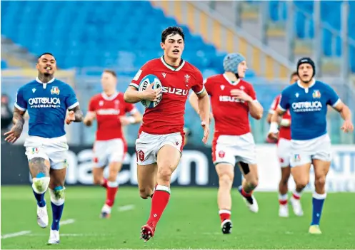  ??  ?? Running free: Wales’s Louis Rees-zammit breaks clear to score his fourth try of this year’s Six Nations in the thrashing of Italy on Saturday