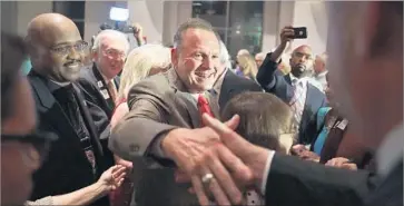  ?? Scott Olson Getty Images ?? ROY MOORE greets supporters in Montgomery after beating Luther Strange, President Trump’s favorite.