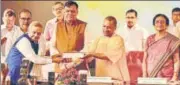  ?? . SUBHANKAR CHAKRABORT­Y/HT PHOTO ?? Industrial­ist Lalit Khaitan handing over a cheque of ₹51 lakh to CM Yogi Adityanath under corporate social responsibi­lity.