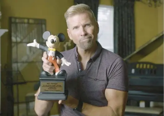  ?? TH ANGEL PRODUCTION­S/COURTESY PHOTOS ?? Billy Flanigan poses with an award he received from Walt Disney World in this image from the documentar­y “Billy Flanigan: Happiest Man on Earth.”