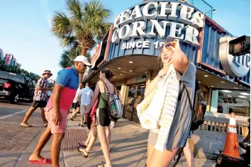  ?? — AFP photo ?? People cross Ocean Blvd in Myrtle Beach, South Carolina. Vacationer­s travelled to the SC beach despite growing concerns about the spread of Covid-19.