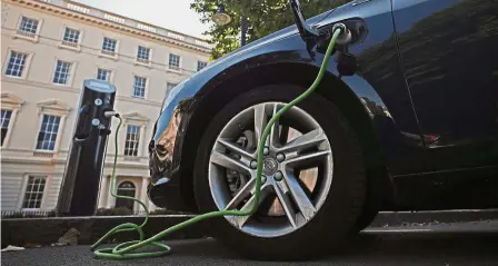  ?? — Reuters ?? Going electric: A Volvo hybrid car is seen connected to a charging point in London. The Sweden-based automaker plans to eventually convert its lineup to all hybrid or electric powertrain­s.