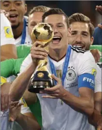  ?? IVAN SEKRETAREV, THE ASSOCIATED PRESS ?? Germany’s Julian Draxler holds up the championsh­ip trophy at the end of the Confederat­ions Cup final against Chile at the St. Petersburg Stadium in Russia on Sunday. Germany won, 1-0.