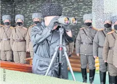  ??  ?? RISKY MOVE: Kim Jong-un, centre, looks through binoculars as soldiers wearing face masks look on during a drill at an undisclose­d location yesterday.