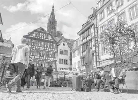  ?? PHOTOS BY ALBERT STUMM ?? The cathedral rises over a square with street performers in the old town. One half of the city looks classicall­y French, while the other side of town was built during German rule.