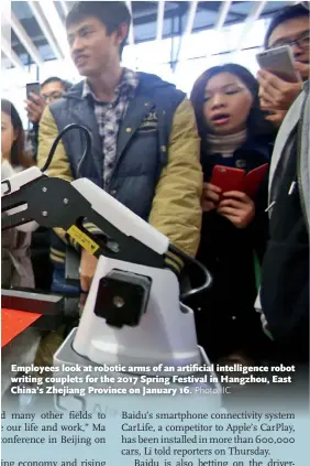  ??  ?? Employees look at robotic arms of an artificial intelligen­ce robot writing couplets for the 2017 Spring Festival in Hangzhou, East China’s Zhejiang Province on January 16.