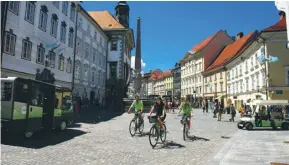  ??  ?? Cycling through Slovenia’s capital, Ljubljana