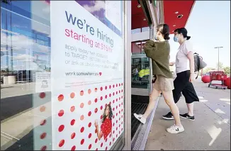  ??  ?? Passers-by walk past a hiring sign as they enter a Target retail store location on Sept 30, 2020, in Westwood, Mass. The number of Americans seeking unemployme­nt benefits declined last week to a still-high 837,000, evi
dence that the economy is struggling to sustain a tentative recovery that began this summer. (AP)