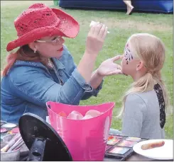  ?? NEWS PHOTO COLLIN GALLANT ?? Christy Vince provides face-painting services to young attendees of Thursday’s annual Medicine Hat Public Library pancake breakfast prior the start of the Medicine Hat Stampede parade.