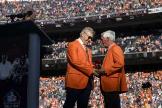  ?? Aaron Ontiveroz, The Denver Post ?? Former Broncos head coach Mike Shanahan is inducted into the team’s Ring of Fame by former quarterbac­k John Elway during halftime against the Las Vegas Raiders at Empower Field at Mile High on Sunday.