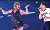  ?? DAVE HOGAN/GETTY IMAGES ?? TAMU SPESIAL: Taylor Swift (kiri) berduet dengan Niall Horan dalam konser di Stadion Wembley, London, Jumat malam.