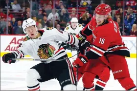  ?? AP/KARL B DEBLAKER ?? Carolina Hurricanes’ Ryan Dzingel (18) collides with Chicago Blackhawks’ Olli Maatta (6), of Finland, during the second period of an NHL hockey game, in Raleigh, N.C., on Saturday.