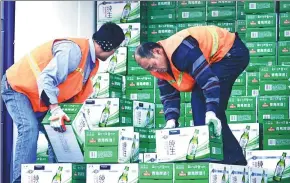  ?? YU FANGPING / FOR CHINA DAILY ?? Workers upload cartons of beer at a Tsingtao Brewery Co Ltd plant in Qingdao, Shandong province.