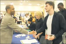  ?? STAFF PHOTO BY TIFFANY WATSON ?? Tyrone Sharpe, recruiter from Goodwill Greater Washington, met Waldorf residents Will Dyer, 19, and Quincy Connell, 17, at the CCPL Young Adult Job Fair on March 22.