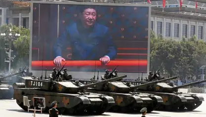  ?? AP ?? THE IMAGE of Chinese President Xi Jinping fills the giant screen in the background as Type 99A2 battle tanks take part in a parade in front of Tiananmen Gate in Beijing.