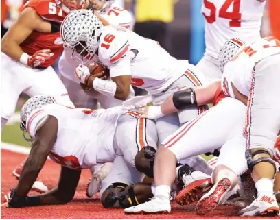  ??  ?? Ohio State quarterbac­k J. T. Barrett scores on a one- yard touchdown run in the second quarter against Wisconsin. | GETTY IMAGES