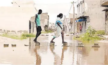  ?? SEYLLOU/GETTY-AFP ?? Deadly flooding in Senegal: Bricks form a path in floodwater­s Monday in the Keurs Massar area of Dakar, Senegal. Heavy rains over the weekend drenched Dakar and major swaths of the West African country. The government came under fire for a perceived lack of response to the flooding, which left at least four people dead, according to rescue workers.