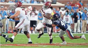  ?? AP ?? Alabama running back Najee Harris (22) runs through a Mississipp­i defender during the first half of their NCAA college football game, Saturday in Oxford, Miss. Alabama won 62-7.