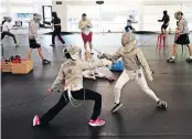  ??  ?? Sahana Ramakrishn­an, 9, left, of Dublin, and Sasha Suspitsyna, 11, right, of Upper Arlington, duel at Columbus Fencing & Fitness in Dublin.