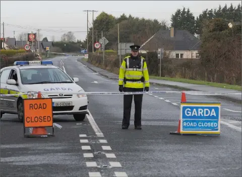  ??  ?? Fellow Gardai protect then scene in the wake of detective Garda Adrian Donohoe’s murder.