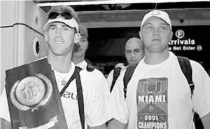  ?? STEVE MITCHELL/AP ?? University of Miami’s Greg Lovelady, with teammate Chris Sheffield, holds the baseball national championsh­ip trophy after the team beat Stanford.