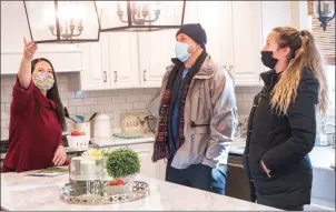  ?? Photo by Michael Derr ?? Real estate agent Shannon Buss, left, shows her clients, Brian and Amanda Baker of Newport, the kitchen of a house for sale at 64 Rockland Drive in Wakefield on Jan. 5.