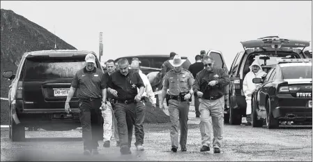  ?? DANNY ZARAGOZA/THE LAREDO MORNING TIMES VIA AP ?? LAW ENFORCEMEN­T OFFICERS GATHER NEAR THE SCENE WHERE THE BODY OF A WOMAN was found near Interstate 35 north of Laredo, Texas on Saturday. A U.S. Border Patrol agent suspected of killing four women was arrested early Saturday after a fifth woman who had been abducted managed to escape from him and notify authoritie­s, law enforcemen­t officials said, describing the agent as a “serial killer.”