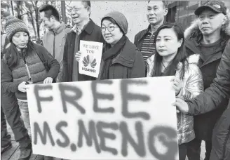  ?? CP PHOTO ?? People hold a sign at a B.C. courthouse prior to the bail hearing for Meng Wanzhou, Huawei’s chief financial officer on Monday.