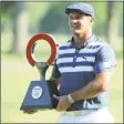  ?? Leon Halip / Getty Images ?? Bryson DeChambeau celebrates with the trophy after winning the Rocket Mortgage Classic on Sunday at the Detroit Golf Club.