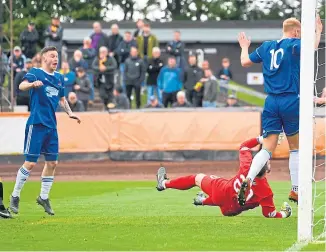  ??  ?? BREAKTHROU­GH: Cove’s Jamie Masson scores an early goal to make it 1-0