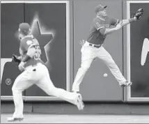  ?? Alex Gallardo Associated Press ?? MIKE TROUT leaps but cannot catch a ball hit for a double by Seattle’s Nelson Cruz as Kole Calhoun runs for the ricochet.