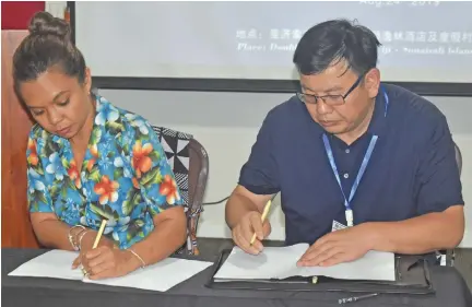  ?? Salote Qalubau ?? From left: Rosie Holidays Asia Inbound manager Azaria Chung and Wuhan Cahozong Culture and Tourism Company Limited Chairman and general manager Kang Haijun sign the promotiona­l contract at the DoubleTree by Hilton Fiji Resort on Sonaisali Island on August 24, 2019. Photo: