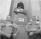  ?? USA TODAY NETWORK - TENNESSEE FILE PHOTO ?? Troopers stand in front of a bust of Nathan Bedford Forrest during a protest at the Tennessee State Capitol in 2017. A protester covered the bust with a black fabric.