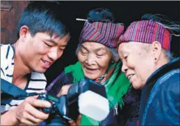  ?? WEN SHUANG / FOR CHINA DAILY ?? A member of Wang’s team shows his photos to two sisters.
