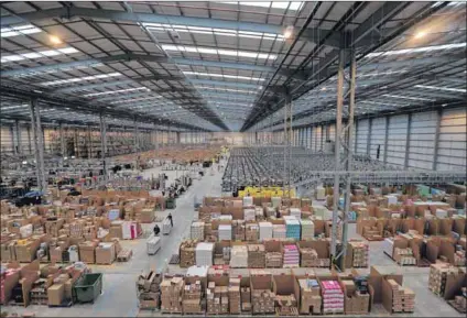  ?? Photos: Oli Scarff/getty Images and Waldo Swiegers/bloomberg/getty Images ?? Changes: Employees sort items in the Amazon warehouse in England (above). Massmart, which owns Game, was bought by Walmart (below). The entry of Amazon is likely to change the e-commerce market in South Africa.