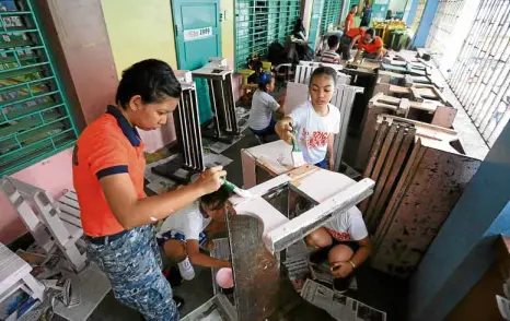  ?? MARIANNE BERMUDEZ ?? REPAINT—FOR THE END (OF VACATION SEASON) IS NEAR! Members of the Philippine Coast Guard help pupils in a “Brigada Eskwela” activity at Pedro Guevarra Elementary School in Binondo, Manila, to spruce up the campus in time for the opening of classes in public schools on June 13.