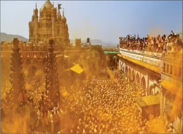  ?? REUTERS ?? Devotees throw turmeric powder as an offering to the shepherd god Khandoba as others carry a palanquin during ‘Somvati Amavasya’ at a temple in Jejuri near Pune on Monday.