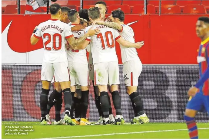  ??  ?? Piña de los jugadores del Sevilla después del golazo de Koundé