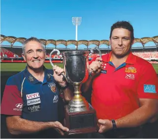  ??  ?? SIMILAR PATHS: Lions coach Chris Fagan and Suns coach Stuart Dew with the Q- Clash trophy.